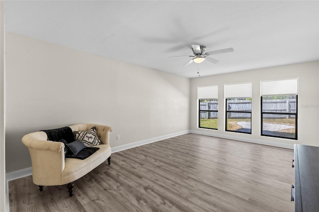 sitting room featuring baseboards, ceiling fan, and wood finished floors