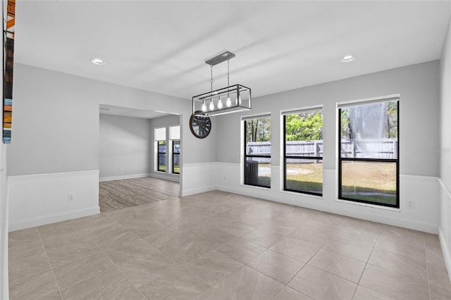 spare room with baseboards and light tile patterned flooring