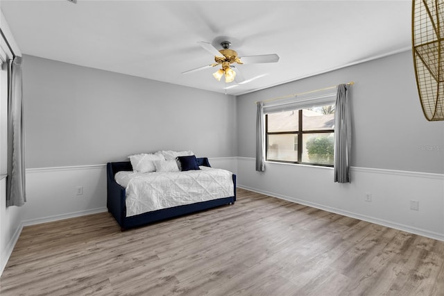 bedroom featuring wood finished floors, baseboards, and ceiling fan