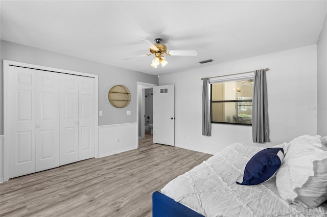 bedroom featuring wood finished floors, visible vents, a closet, and ceiling fan