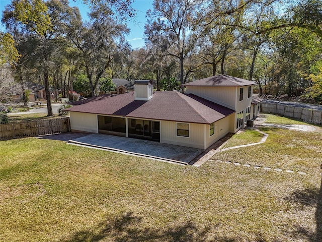 back of house featuring a patio area, a lawn, a fenced backyard, and a shingled roof