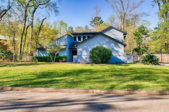 mid-century inspired home featuring a front lawn and fence