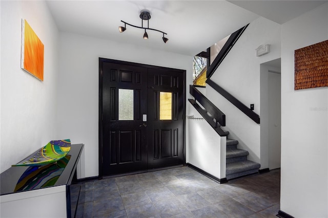 foyer entrance featuring stairway and baseboards