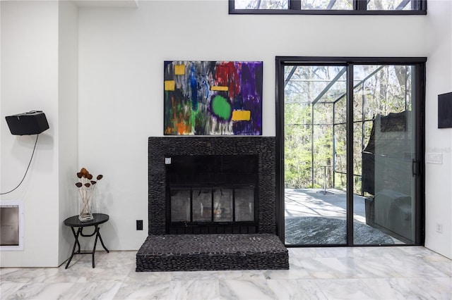 living room with a healthy amount of sunlight, a fireplace, and marble finish floor