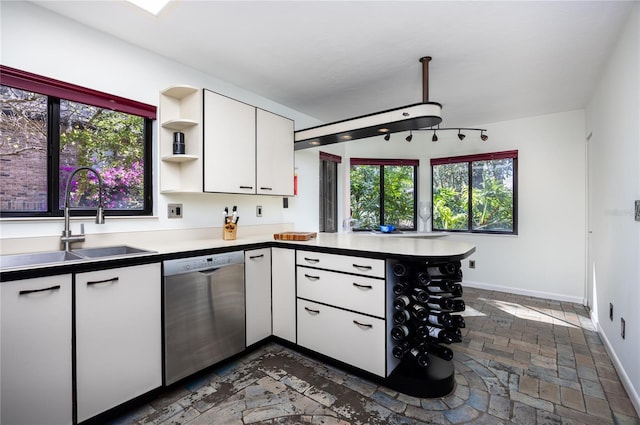 kitchen featuring a sink, open shelves, white cabinetry, a peninsula, and dishwasher