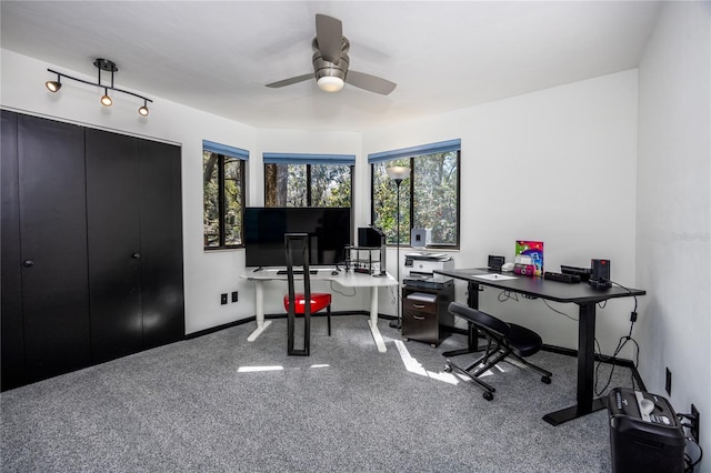 carpeted office space featuring plenty of natural light, baseboards, and a ceiling fan