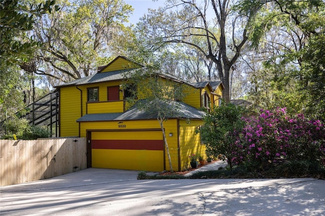 view of front of property featuring fence, a garage, and driveway