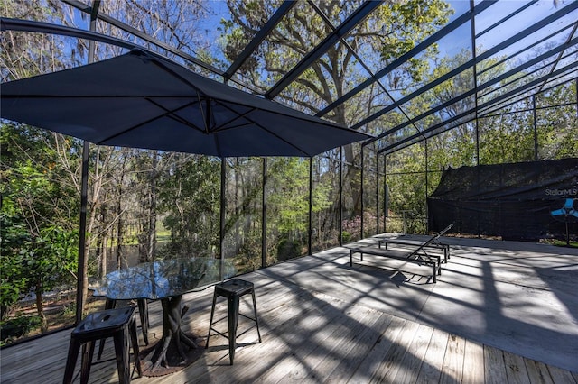 wooden terrace with outdoor dining area and a wooded view