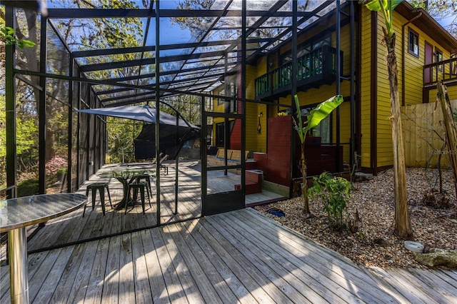 wooden deck with glass enclosure and outdoor dining area