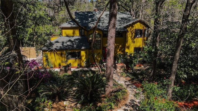 view of front of property featuring a wooded view