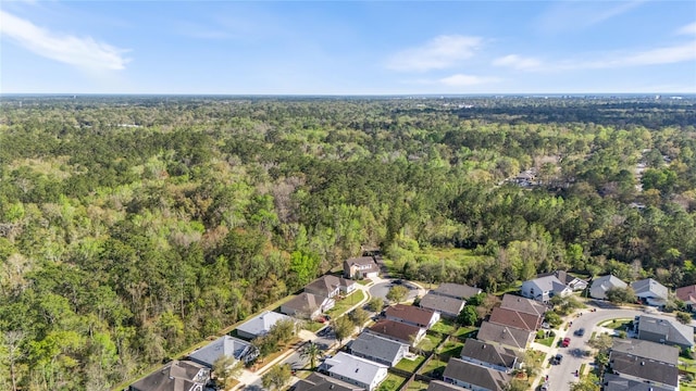 drone / aerial view featuring a forest view and a residential view