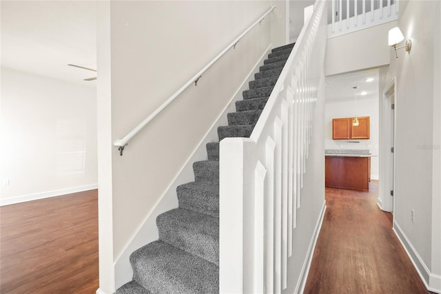 stairway featuring baseboards and wood finished floors