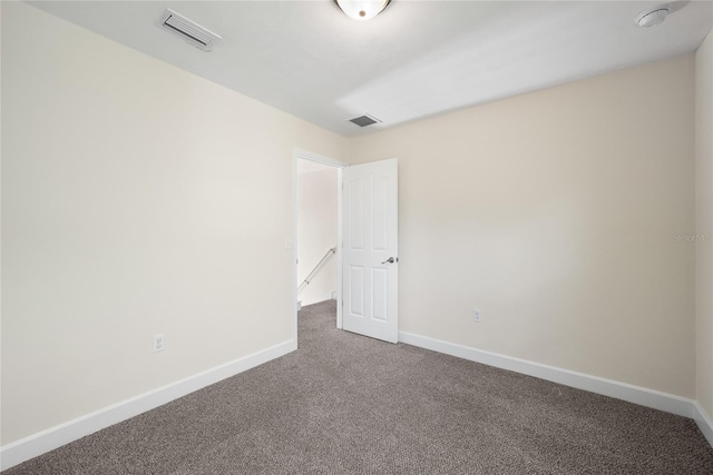 empty room with visible vents, baseboards, and carpet