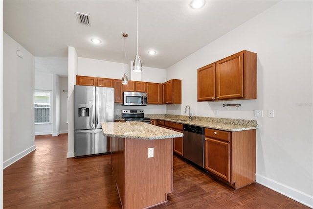 kitchen with visible vents, a kitchen island, dark wood finished floors, appliances with stainless steel finishes, and a sink