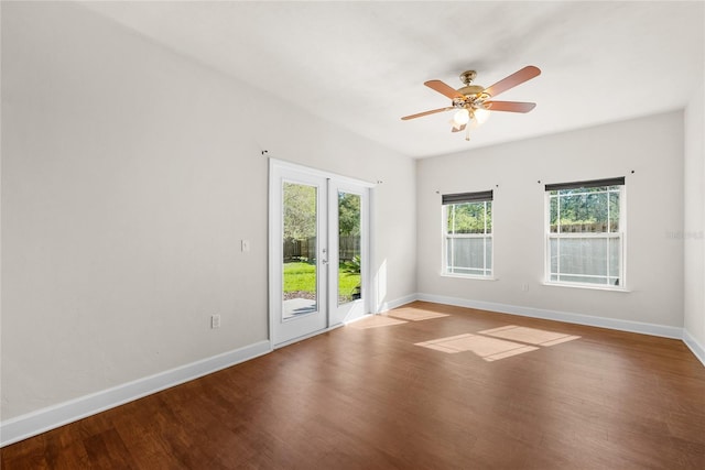 empty room featuring a ceiling fan, baseboards, and wood finished floors