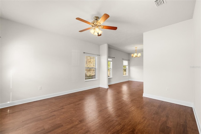 empty room featuring visible vents, baseboards, dark wood finished floors, and ceiling fan with notable chandelier