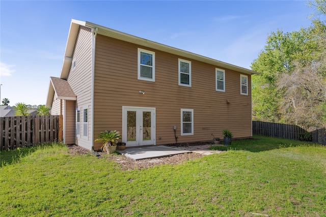 rear view of property with a patio, a lawn, a fenced backyard, and french doors