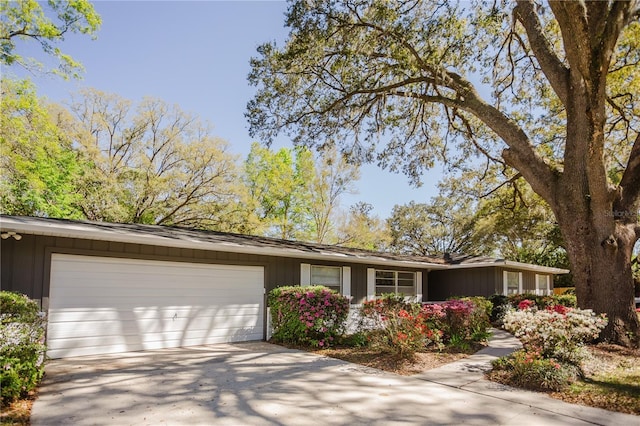 ranch-style house featuring board and batten siding, concrete driveway, and an attached garage