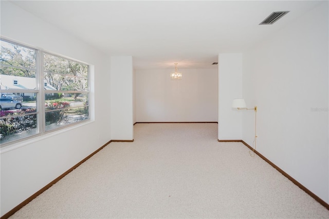 unfurnished room with light carpet, baseboards, visible vents, and a chandelier