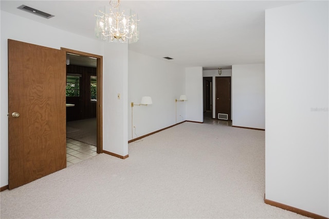 unfurnished room featuring baseboards, visible vents, carpet floors, and a chandelier