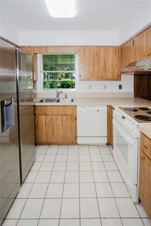 kitchen with white appliances, range hood, light tile patterned floors, a sink, and light countertops