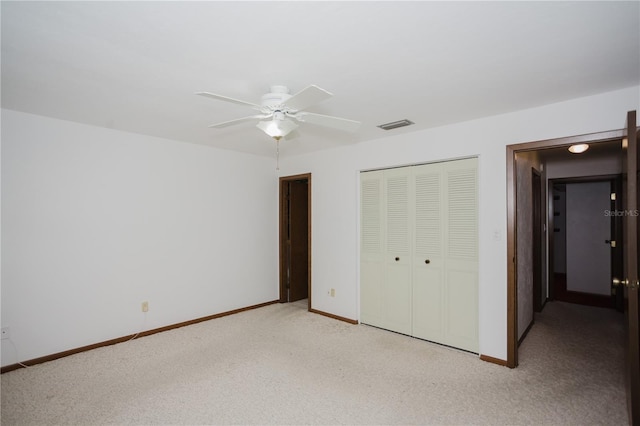 unfurnished bedroom with a closet, visible vents, light colored carpet, and baseboards