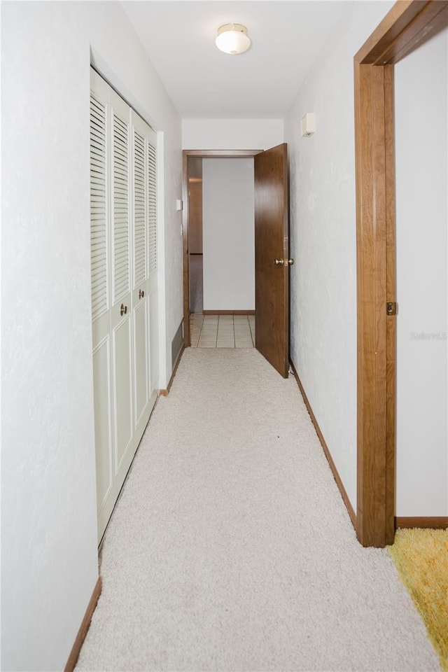 corridor with baseboards and carpet floors