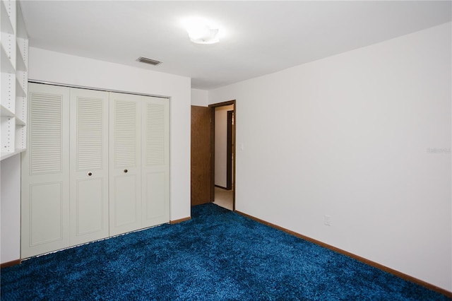 unfurnished bedroom featuring a closet, visible vents, dark carpet, and baseboards