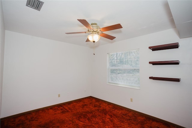 empty room featuring visible vents, baseboards, a ceiling fan, and dark colored carpet