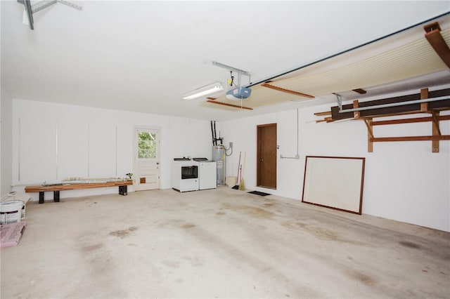 garage featuring water heater, a garage door opener, and washing machine and clothes dryer