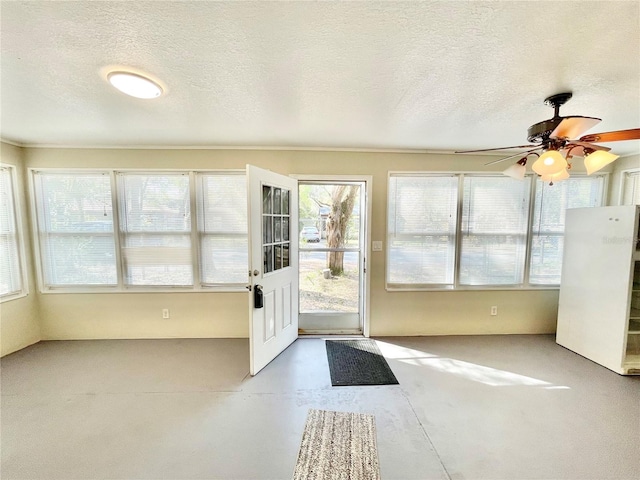 unfurnished sunroom featuring a ceiling fan