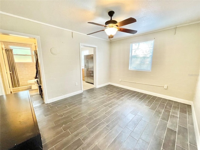 unfurnished bedroom with ornamental molding, dark wood finished floors, connected bathroom, stainless steel fridge with ice dispenser, and baseboards