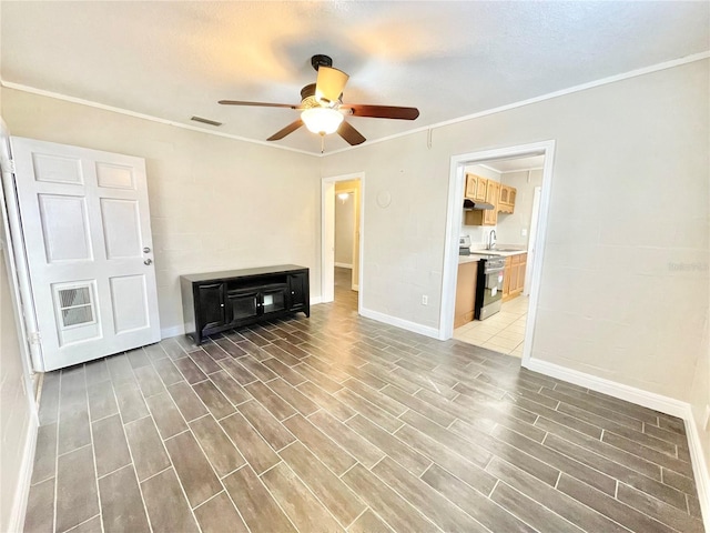 unfurnished living room with a sink, wood finished floors, ceiling fan, and crown molding