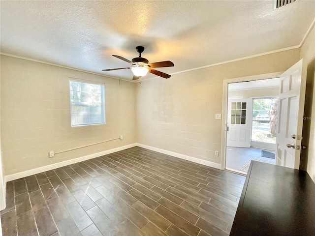 empty room with a textured ceiling, dark wood-type flooring, ornamental molding, and ceiling fan