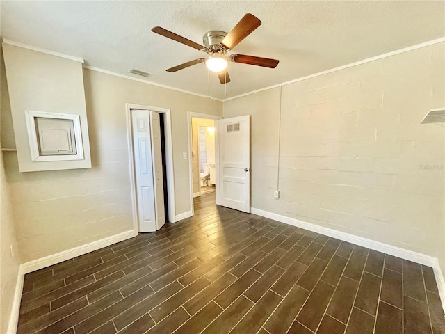 unfurnished bedroom with visible vents, a ceiling fan, crown molding, baseboards, and dark wood-style flooring