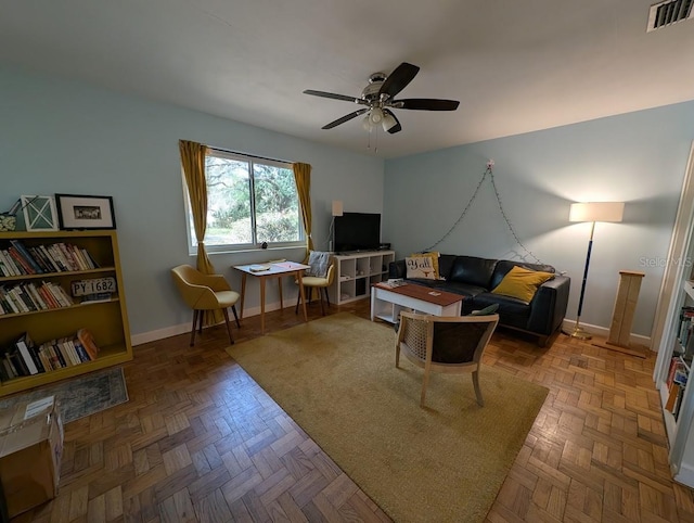 living room featuring visible vents, baseboards, and a ceiling fan