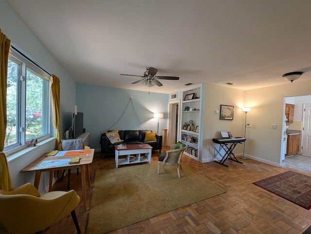 living room featuring visible vents, baseboards, and ceiling fan