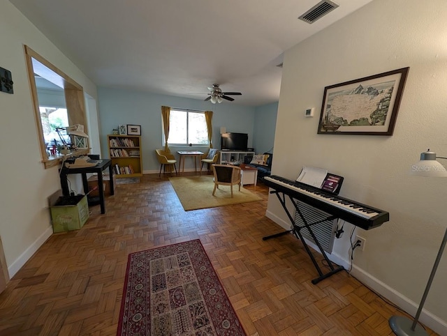 office space featuring baseboards, visible vents, and ceiling fan