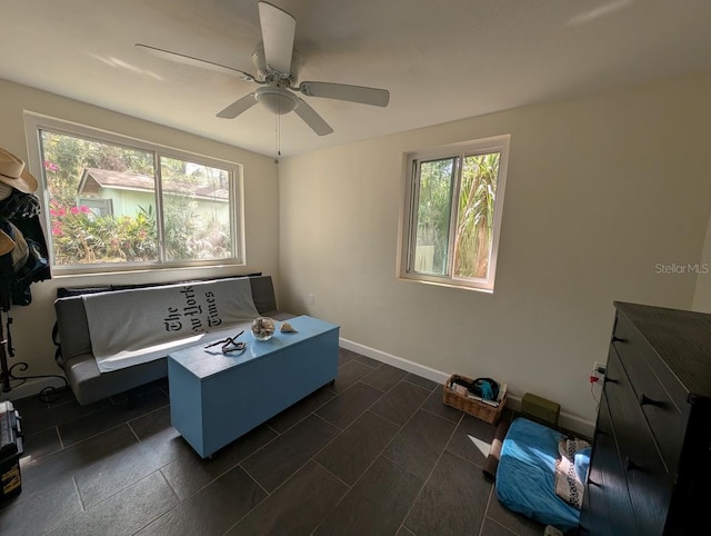 interior space featuring a ceiling fan and baseboards