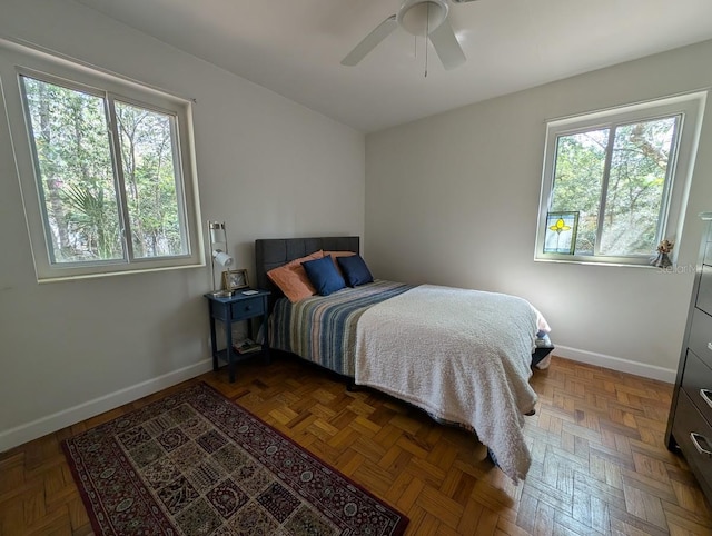 bedroom with baseboards, multiple windows, and a ceiling fan