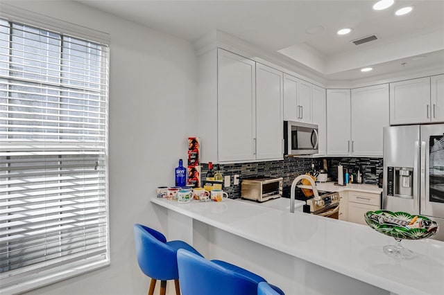 kitchen featuring visible vents, recessed lighting, appliances with stainless steel finishes, light countertops, and decorative backsplash