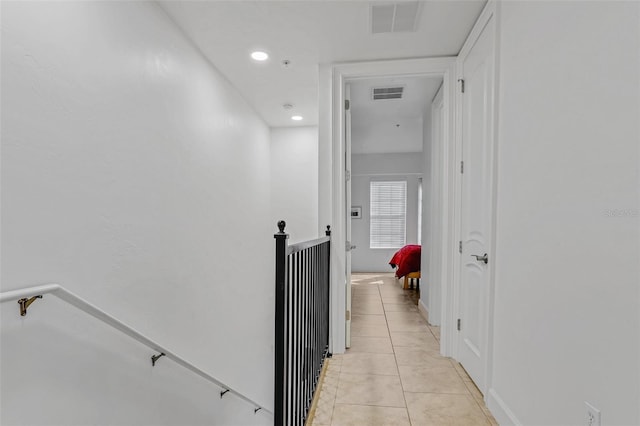 corridor featuring an upstairs landing, visible vents, recessed lighting, and light tile patterned flooring