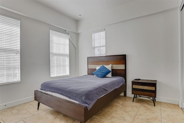 bedroom with light tile patterned floors and baseboards