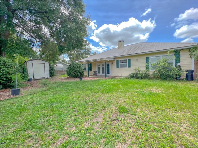 back of property with a storage unit, an outbuilding, french doors, a yard, and a chimney