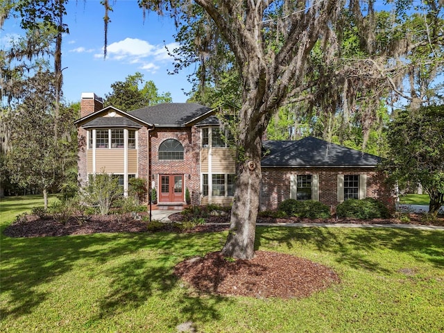 1118 SW 112th St, Gainesville, FL 32607 - view of front of house with a front lawn, french doors, a shingled roof, brick siding, and a chimney