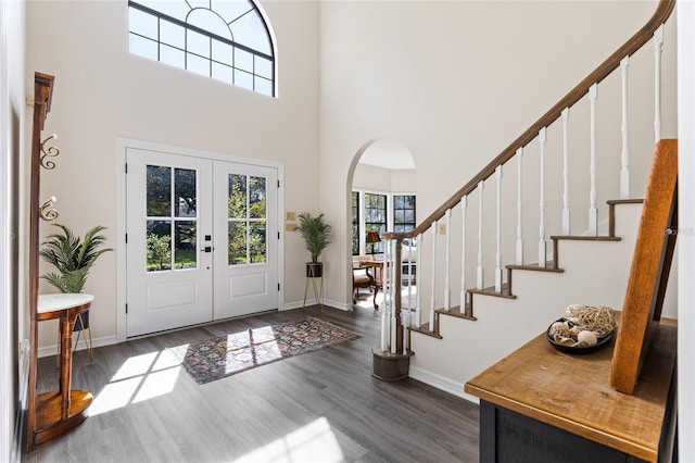 1118 SW 112th St, Gainesville, FL 32607 - foyer with baseboards, stairs, a towering ceiling, wood finished floors, and arched walkways