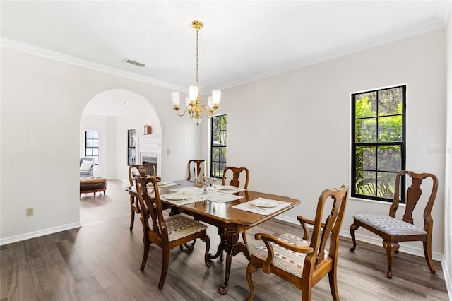 1118 SW 112th St, Gainesville, FL 32607 - dining space featuring wood finished floors, visible vents, arched walkways, and a chandelier