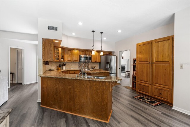 1118 SW 112th St, Gainesville, FL 32607 - kitchen with visible vents, backsplash, appliances with stainless steel finishes, a peninsula, and brown cabinetry