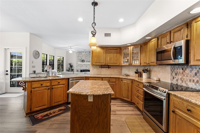 1118 SW 112th St, Gainesville, FL 32607 - kitchen with visible vents, a sink, a kitchen island, stainless steel appliances, and a peninsula