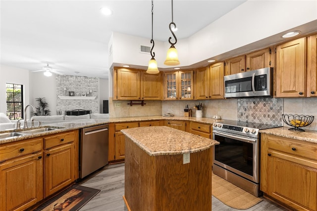 1118 SW 112th St, Gainesville, FL 32607 - kitchen featuring visible vents, a ceiling fan, a center island, stainless steel appliances, and a large fireplace